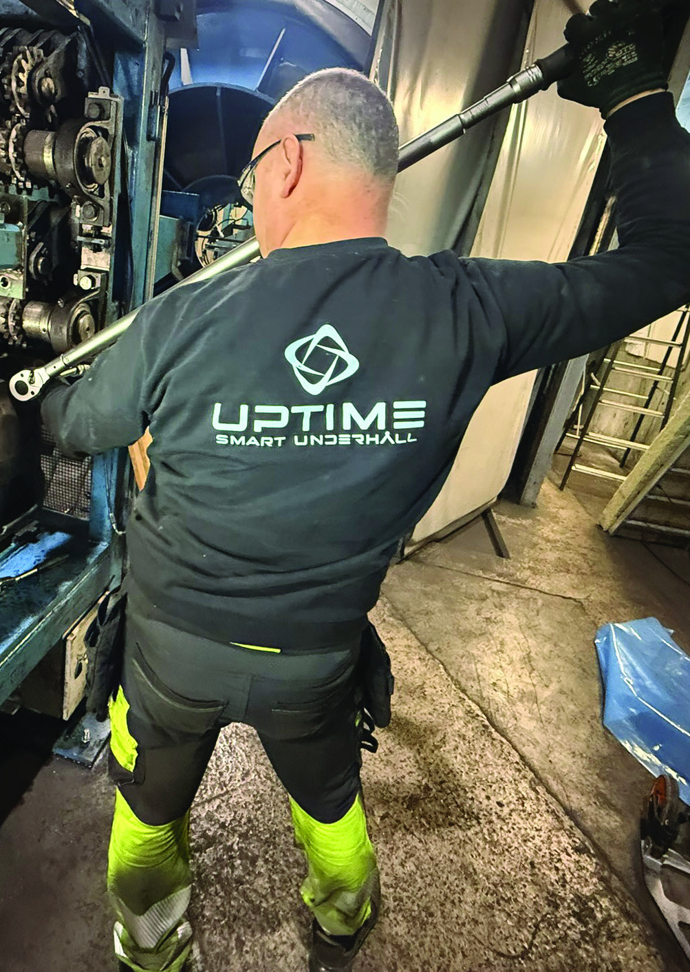 Tekniker med momentnyckel vid stor maskin