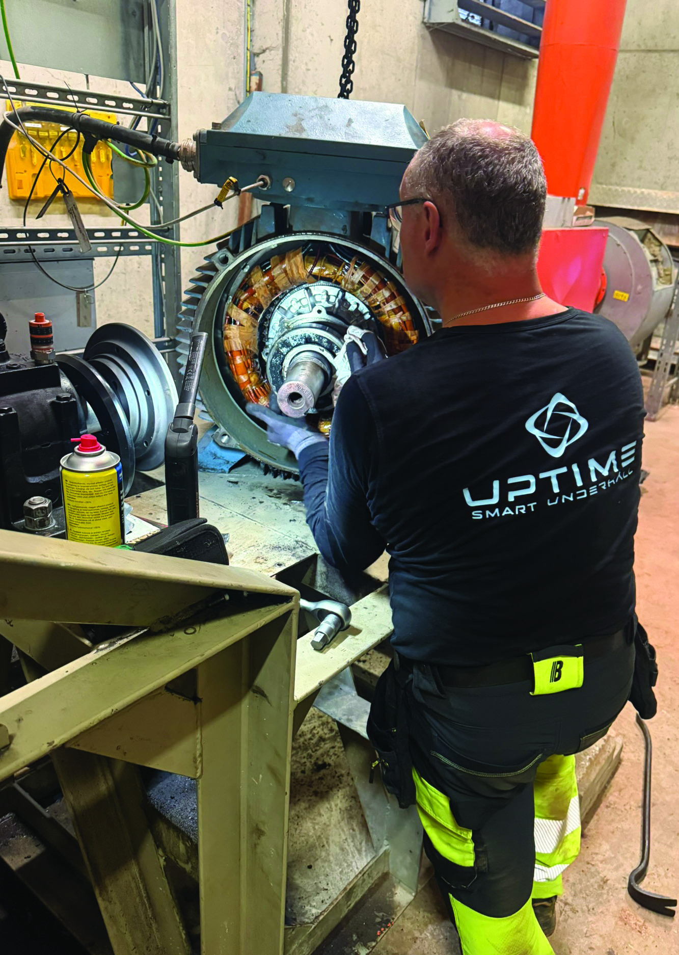 Tekniker rengör statorlindningar i stor elmotor